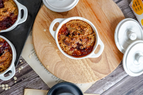 Small white handled ramekins with gluten-free peanut butter and jelly baked oats.