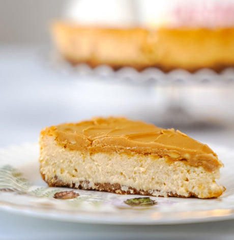 grain-free vegan slice of pumpkin spiced cheesecake with glaze
