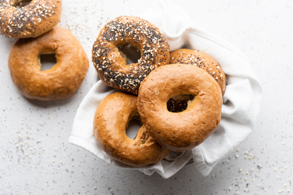Bowl of bagels, some plain and some with sesame and poppy seeds. Grain-free bagels made with Cassava Flour.
