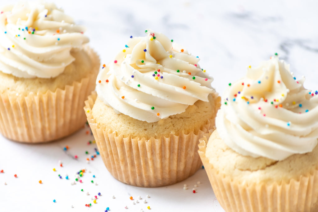 Three Grain-Free White Cupcakes with sprinkles