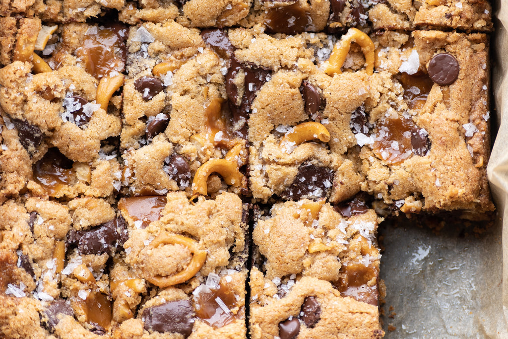 Cut grain-free cookie bars made with chocolate, caramel, and pretzels.