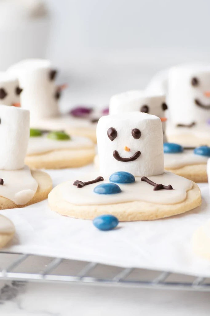Grain-free cut-out sugar cookie decorated to look like a melting snowman. Decorated with icing, colored candies, chocolate and marshmallow.