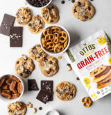 Grain-free kitchen sink cookies on countertop with bowl of pretzels, caramels, and chocolate bar pieces